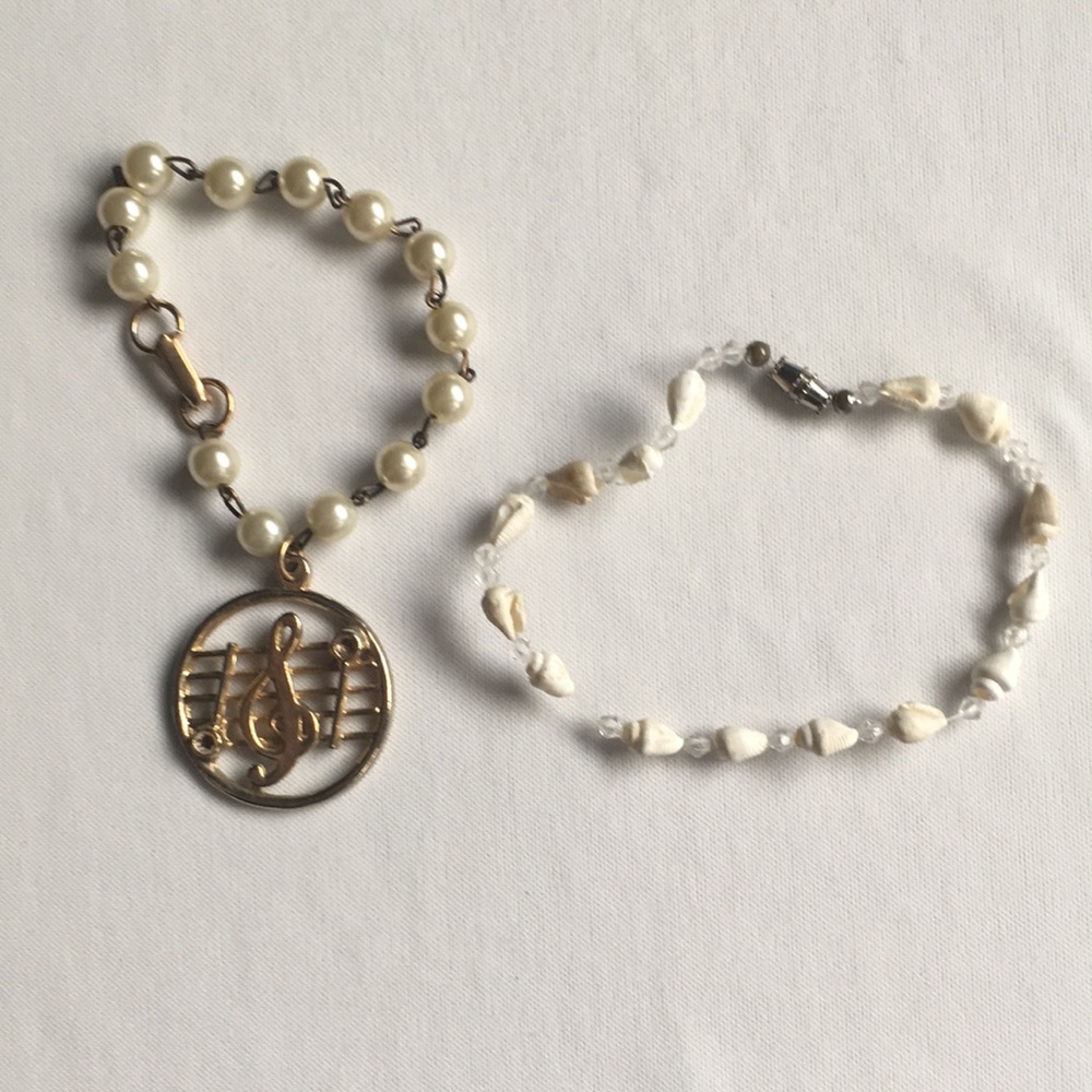 2 bracelets. Seashells & gold toned music …